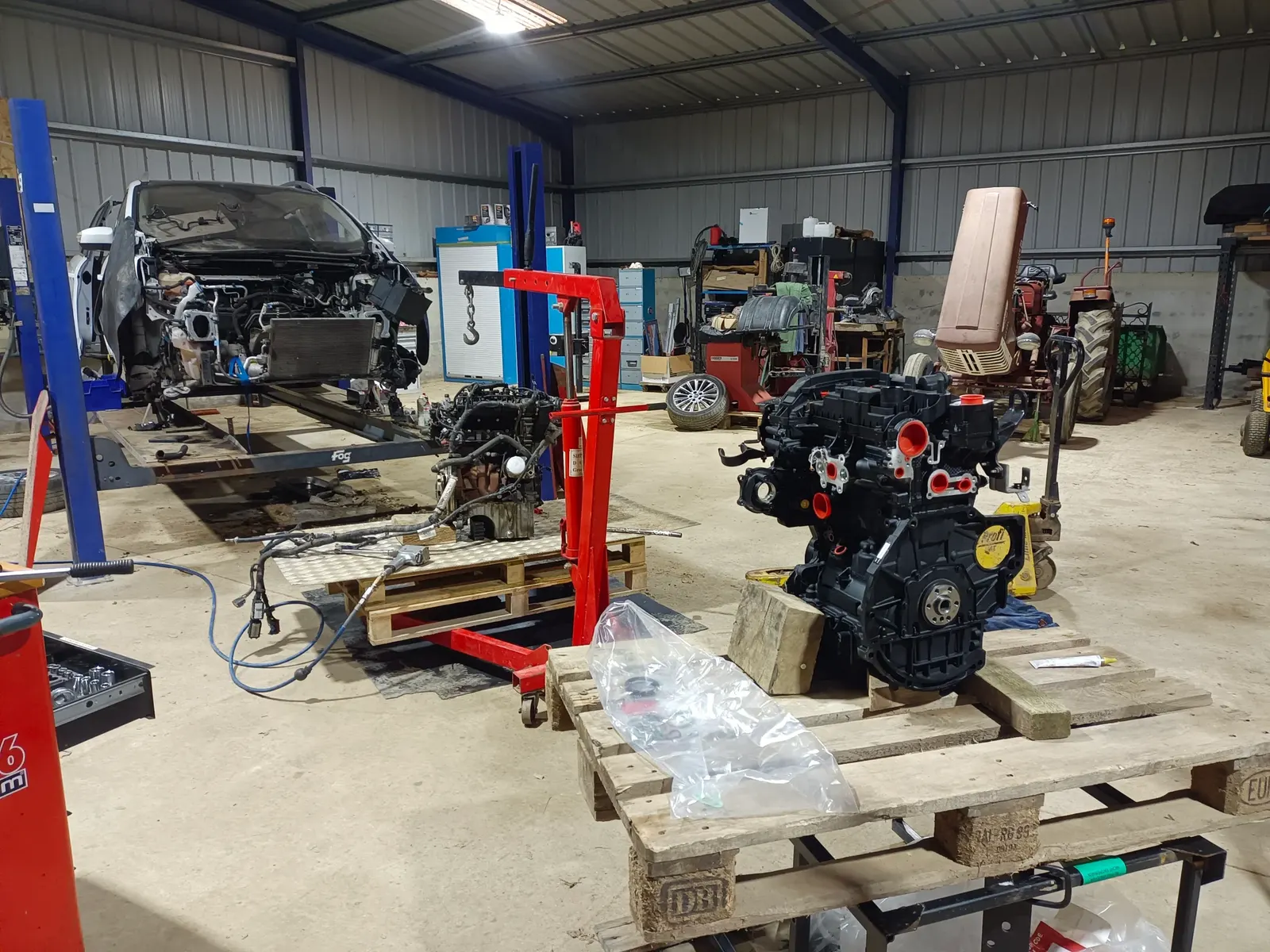 Atelier de L'Atelier Mobile de Loic : moteur déposé sur palette, grue d'atelier et outillage