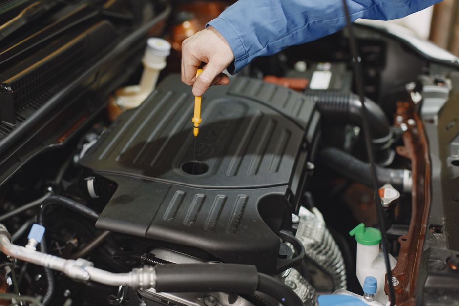 Contrôle du niveau d'huile à la jauge dans le compartiment moteur d'une voiture